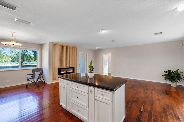 13390 SW 26th St, Davie, FL 33325 - kitchen with a chandelier, dark wood-style floors, a fireplace, white cabinets, and a kitchen island