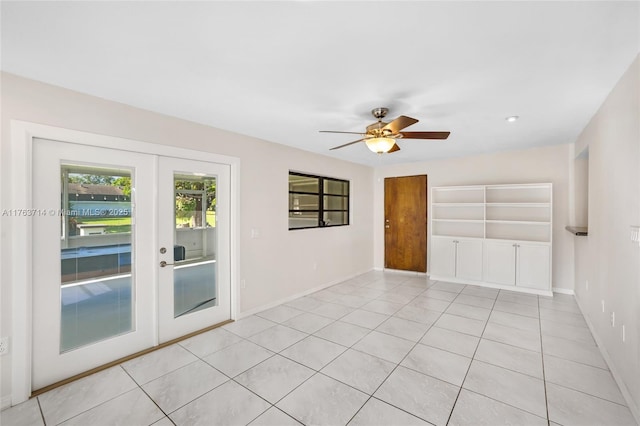 unfurnished room with light tile patterned flooring, baseboards, and ceiling fan