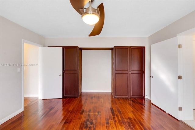 unfurnished bedroom with baseboards, dark wood-style flooring, and ceiling fan