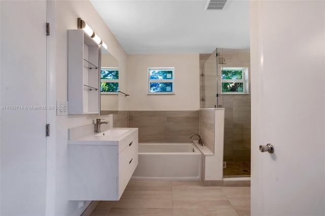 full bathroom with visible vents, a stall shower, vanity, and a garden tub