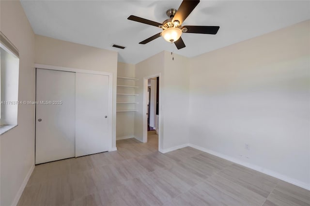 unfurnished bedroom with a ceiling fan, baseboards, visible vents, and a closet