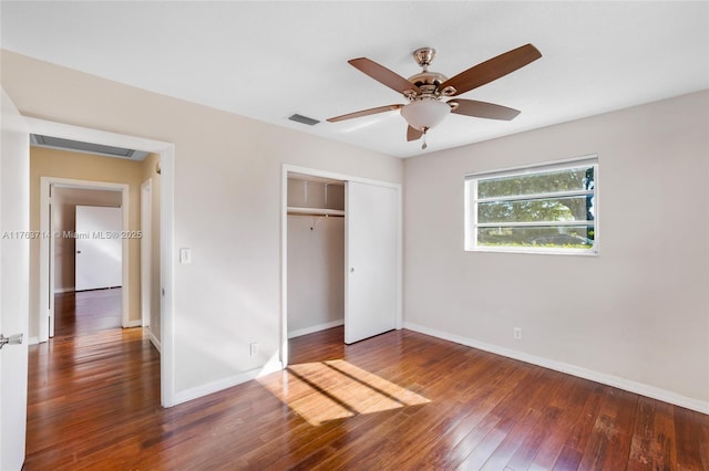 unfurnished bedroom with visible vents, baseboards, a closet, and hardwood / wood-style flooring