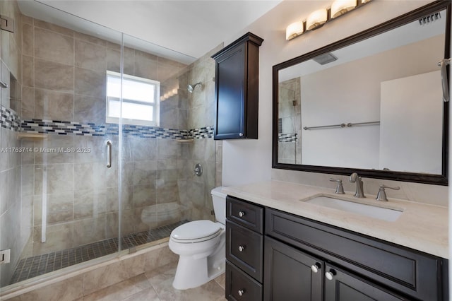 bathroom with vanity, a shower stall, toilet, and tile patterned flooring