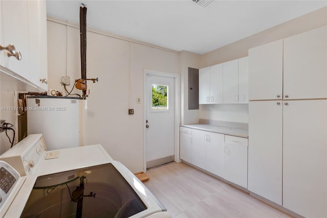 laundry area featuring light floors, electric panel, cabinet space, gas water heater, and washer and clothes dryer