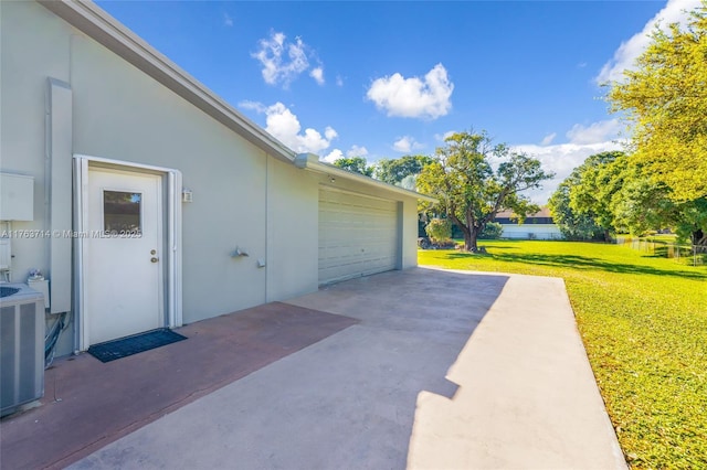 garage with concrete driveway and cooling unit