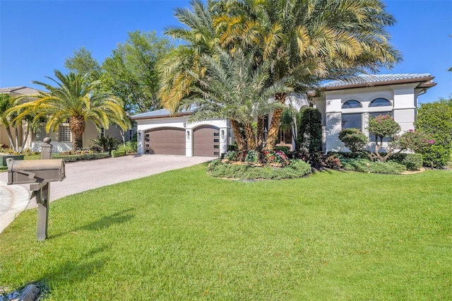 view of front facade featuring driveway, stucco siding, a front lawn, a garage, and a tile roof