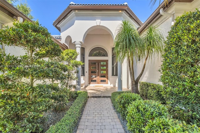 view of exterior entry with stucco siding and french doors