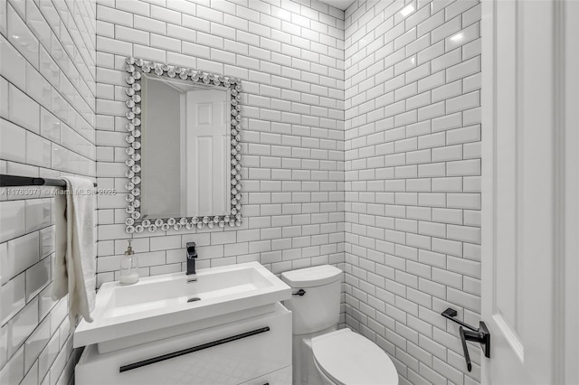 half bath featuring decorative backsplash, vanity, toilet, and tile walls