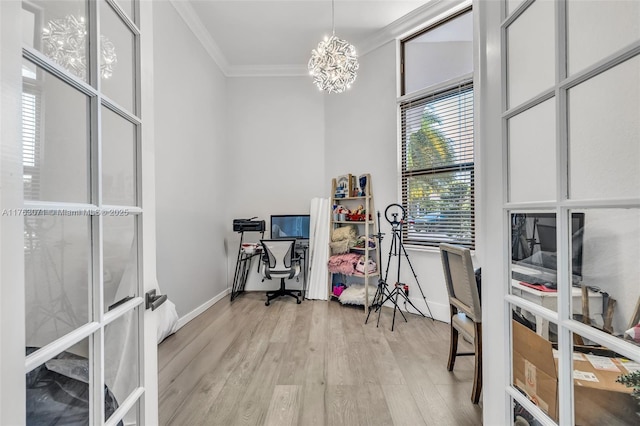 office featuring baseboards, ornamental molding, light wood-style floors, french doors, and a notable chandelier