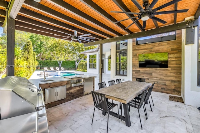 view of patio / terrace with outdoor dining space, an outdoor kitchen, an outdoor pool, a ceiling fan, and a sink