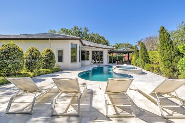 view of pool with a pool with connected hot tub and a patio area