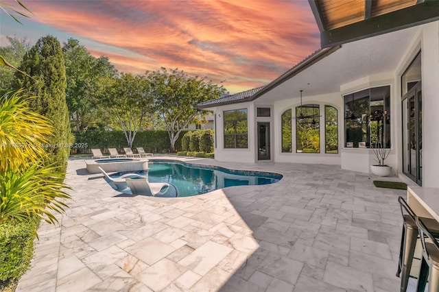 view of pool with a pool with connected hot tub and a patio