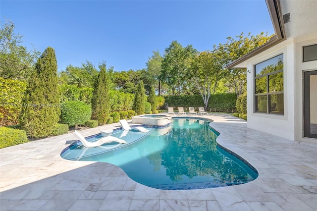 view of swimming pool featuring a pool with connected hot tub and a patio area