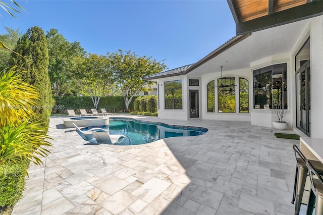 view of swimming pool featuring a pool with connected hot tub and a patio area