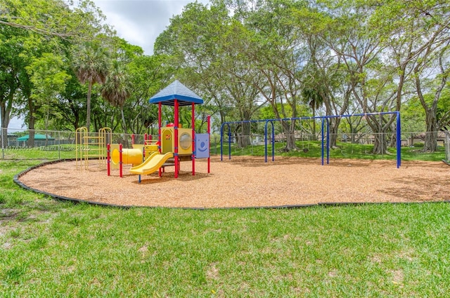 community jungle gym with fence and a lawn