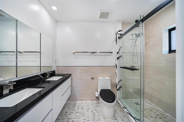 full bathroom featuring tile walls, toilet, visible vents, and a sink