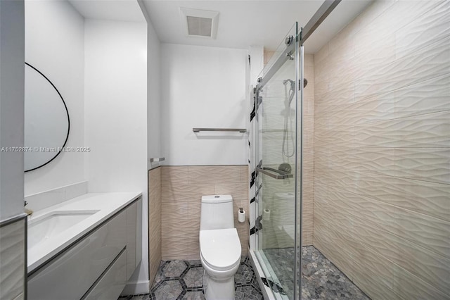 bathroom featuring visible vents, toilet, tile walls, and a stall shower