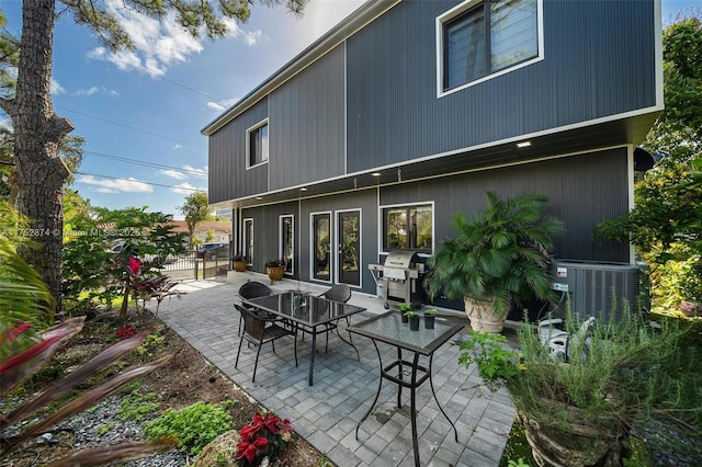 rear view of property with a patio area, central AC, and fence