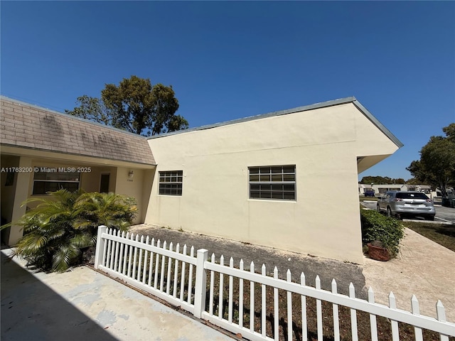 exterior space featuring a fenced front yard and stucco siding