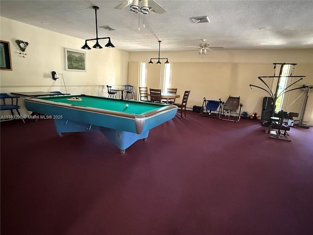 recreation room with visible vents, a textured ceiling, and ceiling fan