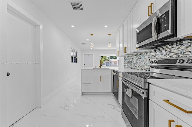 kitchen featuring visible vents, marble finish floor, backsplash, stainless steel appliances, and a peninsula