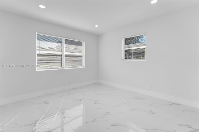 empty room featuring recessed lighting and baseboards