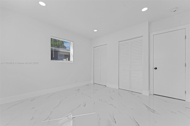 unfurnished bedroom with recessed lighting, baseboards, multiple closets, and marble finish floor