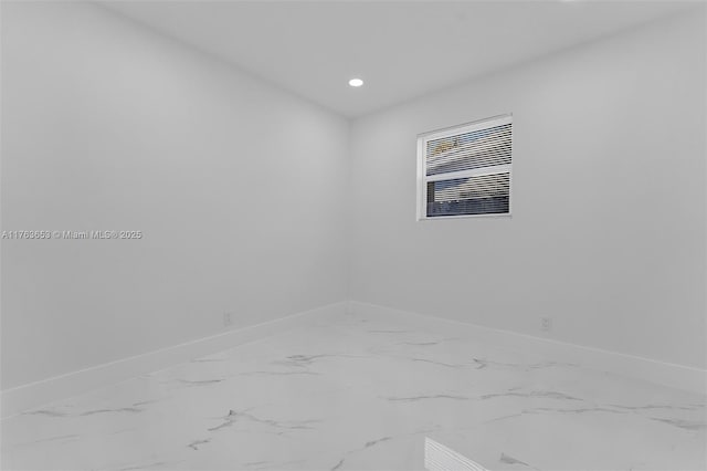 spare room with recessed lighting, marble finish floor, and baseboards