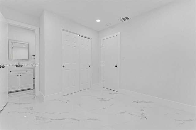 interior space featuring baseboards, visible vents, recessed lighting, a sink, and marble finish floor