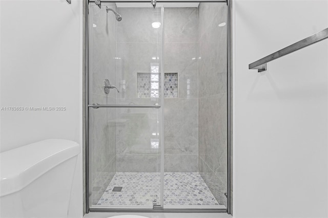 full bathroom with a stall shower and toilet