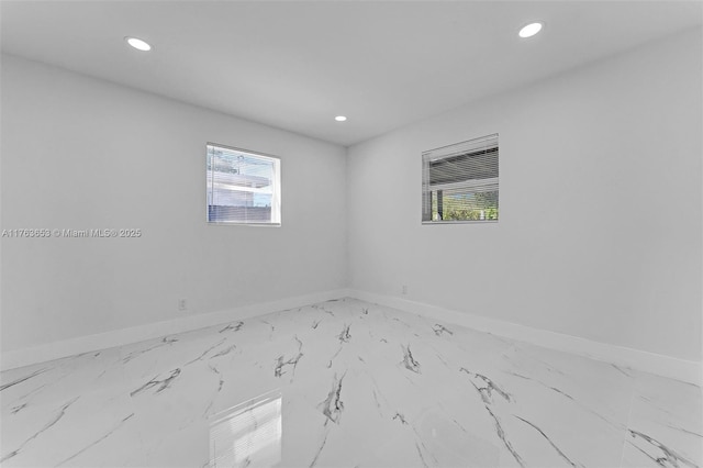 empty room featuring recessed lighting and baseboards