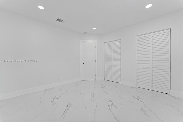 unfurnished bedroom featuring recessed lighting, visible vents, baseboards, and two closets