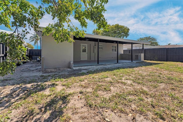 rear view of property with a patio area, a fenced backyard, and stucco siding