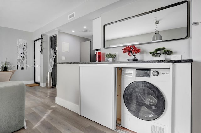 clothes washing area featuring wood finished floors, visible vents, laundry area, washer / clothes dryer, and recessed lighting