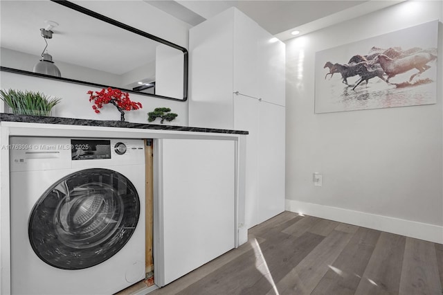 clothes washing area featuring laundry area, washer / clothes dryer, baseboards, and wood finished floors