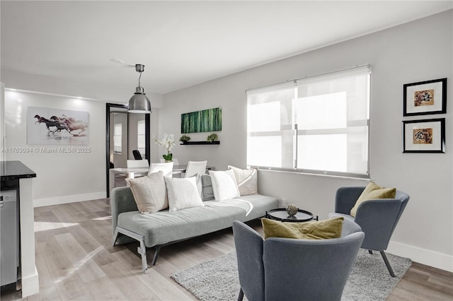 living area with baseboards and light wood-type flooring