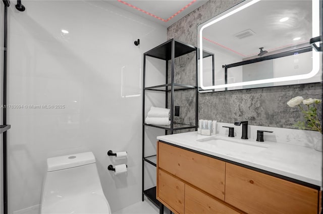 bathroom with vanity, toilet, tasteful backsplash, and visible vents