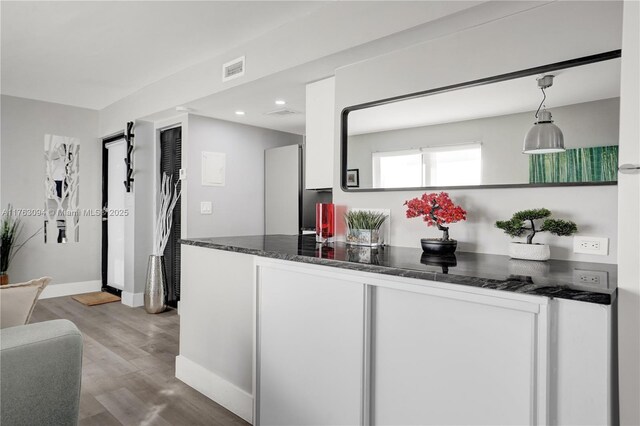 619 Euclid Ave Unit 1B, Miami Beach, FL 33139 - kitchen with wood finished floors, baseboards, recessed lighting, dark stone counters, and hanging light fixtures