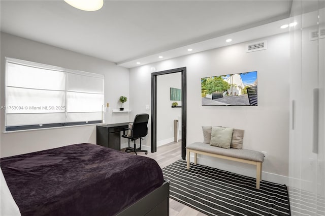 bedroom with recessed lighting, visible vents, baseboards, and wood finished floors