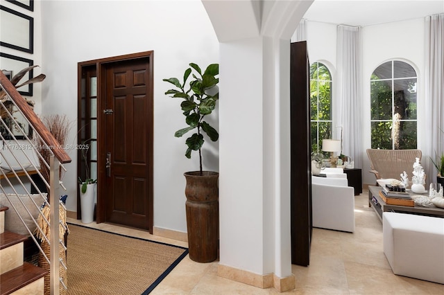 foyer featuring stairs and baseboards