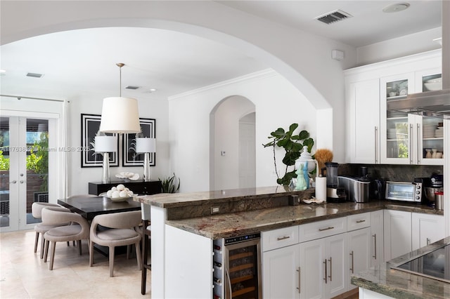 kitchen with dark stone countertops, visible vents, wine cooler, glass insert cabinets, and white cabinetry