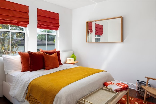 bedroom with wood finished floors and baseboards