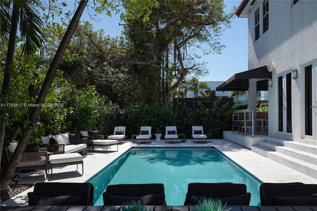 view of swimming pool with an outdoor living space, a fenced in pool, a patio, and fence