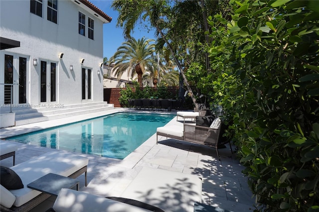 view of pool with entry steps, fence, a patio area, and a fenced in pool