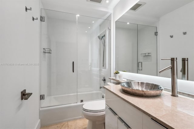 full bath featuring combined bath / shower with glass door, toilet, vanity, and visible vents