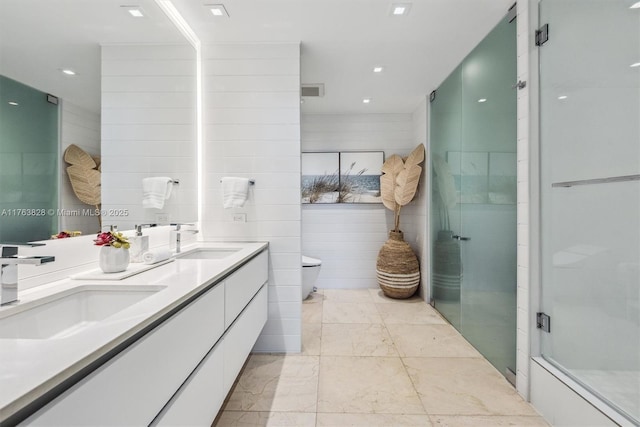 bathroom with a shower stall, toilet, marble finish floor, and a sink