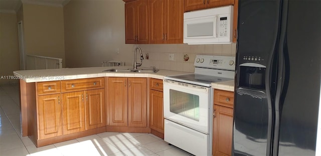 kitchen with white appliances, a peninsula, a sink, light countertops, and backsplash