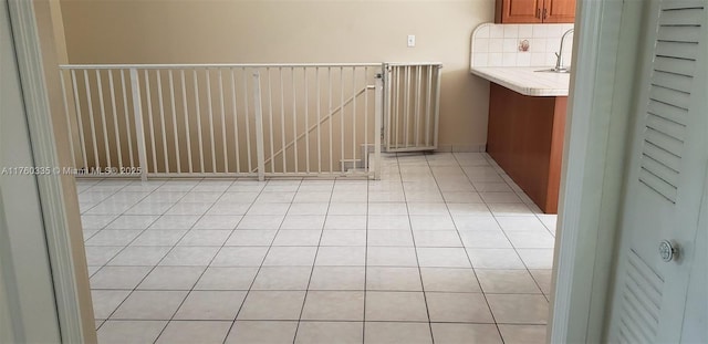 interior space featuring light tile patterned flooring and a sink