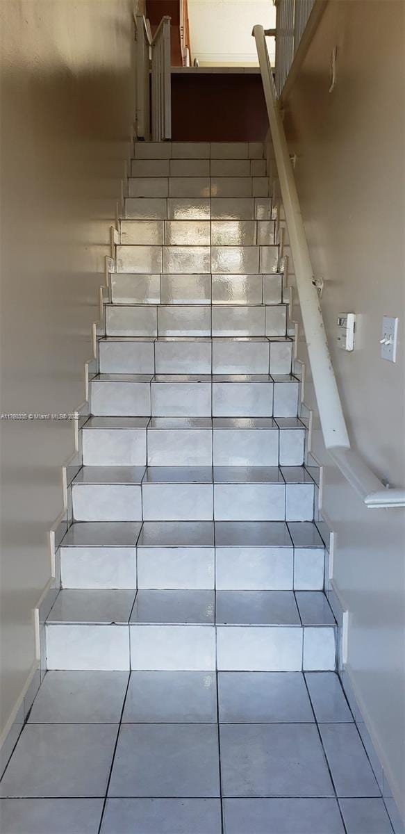 stairs with tile patterned flooring and baseboards