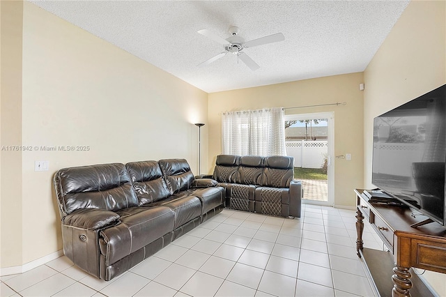 living room with light tile patterned floors, baseboards, a textured ceiling, and ceiling fan